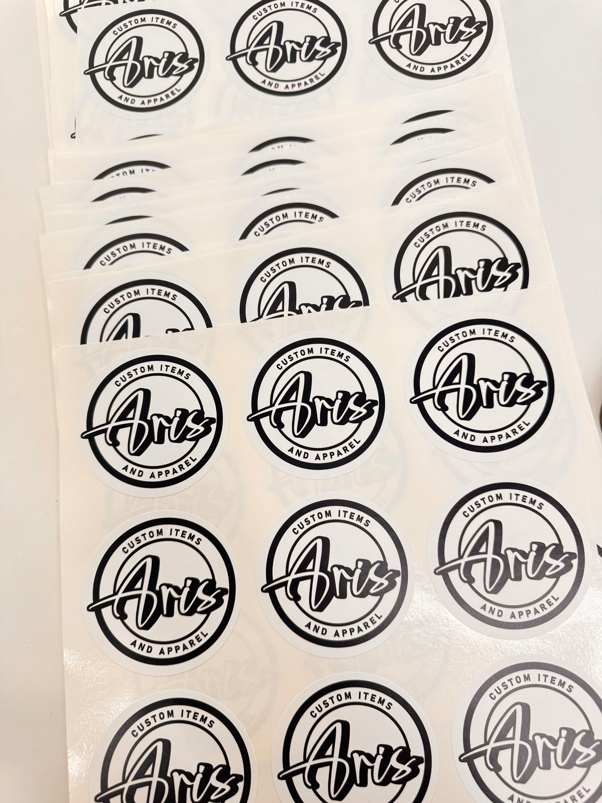 Sheet of black 'Aris' logo stickers on a white background